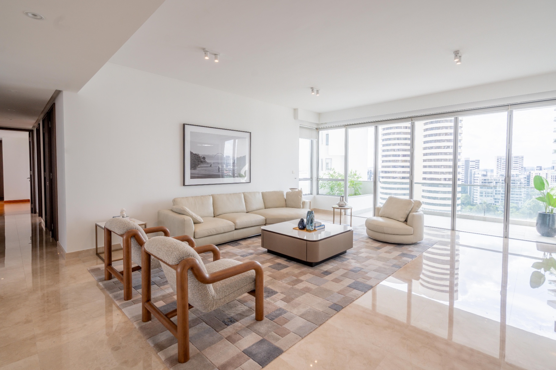 Draycott 8 — living room with leather sectional and floor-to-ceiling balcony windows