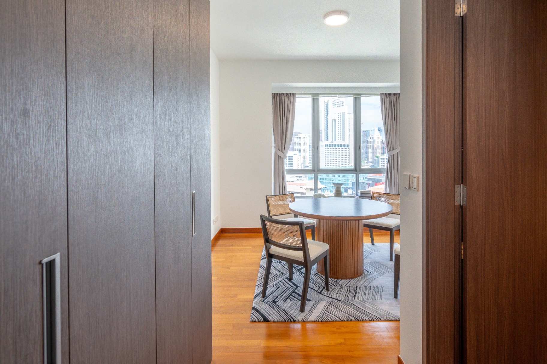 Draycott 8 — bedroom study nook with round table and CBD skyline view